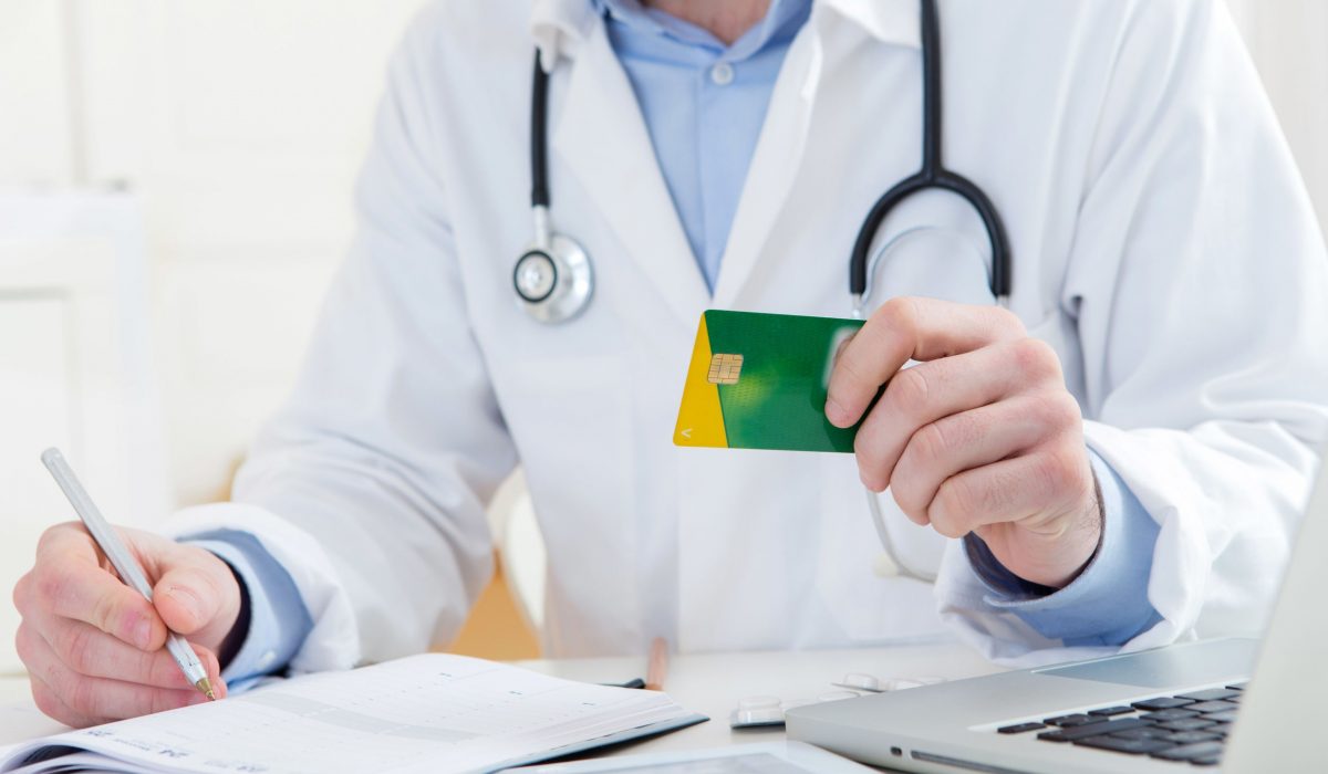 View of a Young attractive doctor taking health insurance card